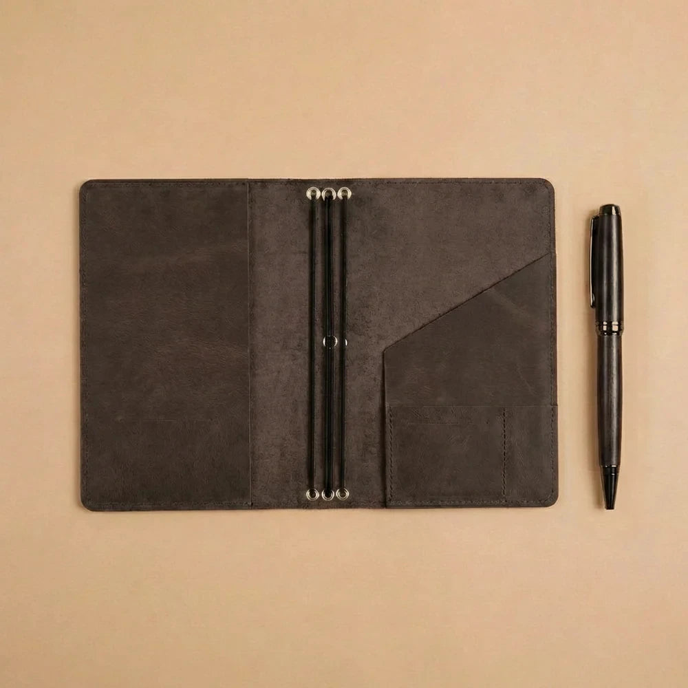 Handmade leather notebook organizer featuring durable elastic cords and functional storage compartments.