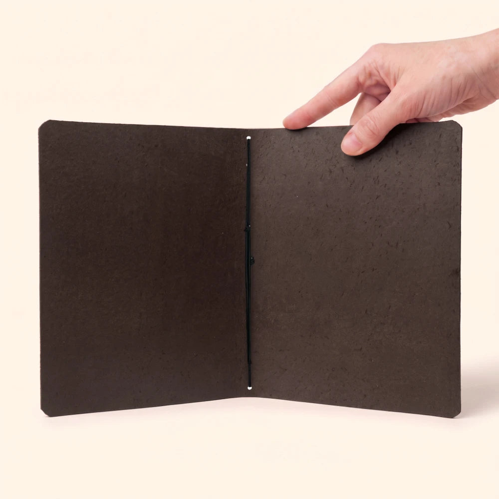 Elegant genuine leather cover holding a plain notebook securely with one elastic band.
