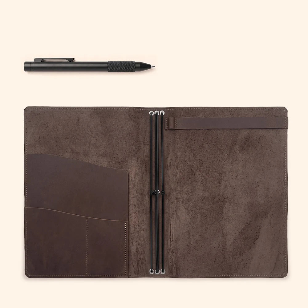 Genuine leather notebook wrap opened to display layered storage and flexible attachment cords.