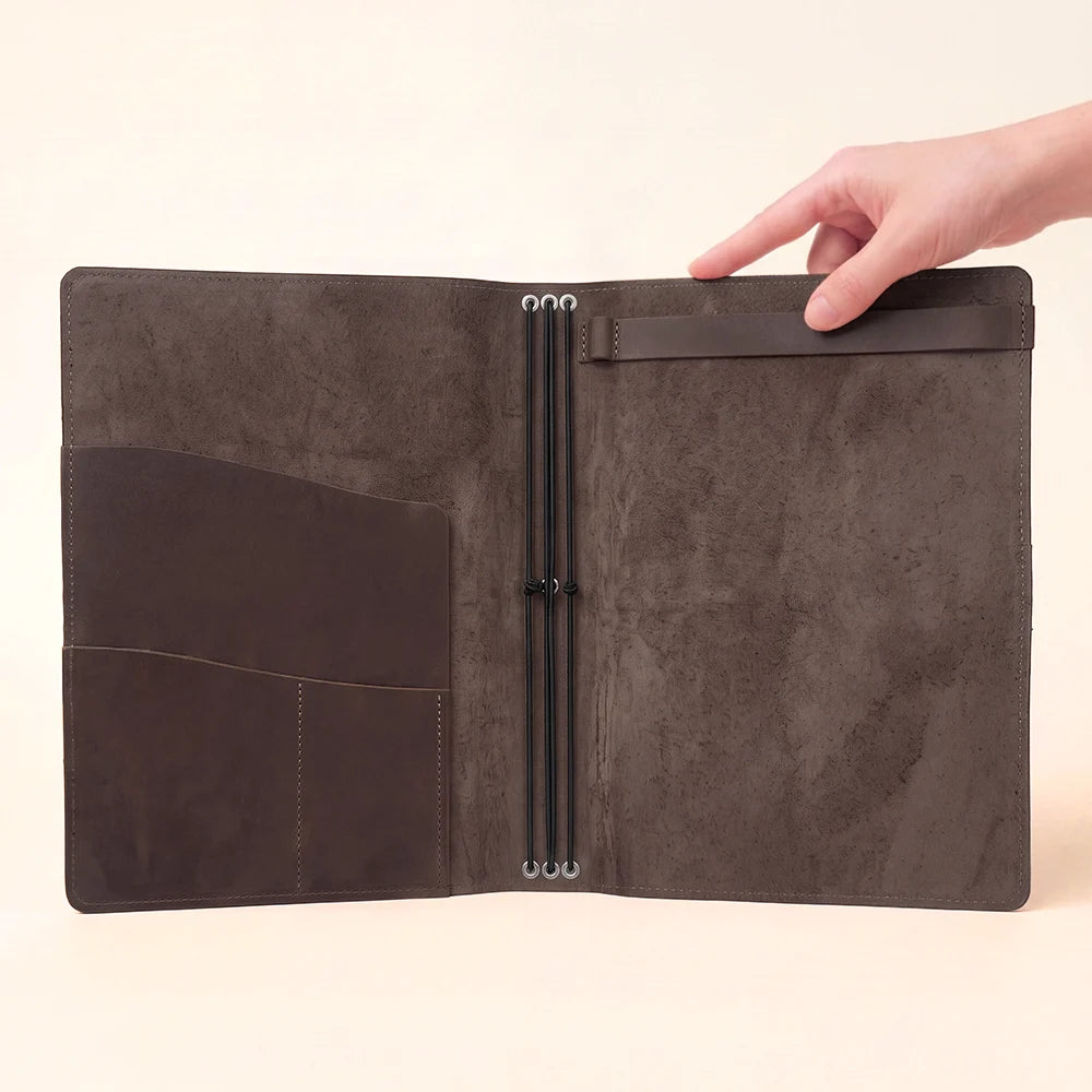 Genuine leather notebook organizer arranged with elastic holders for interchangeable paper inserts.