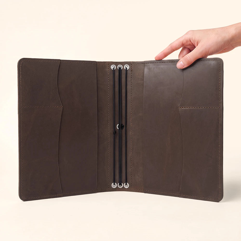 Handmade notebook cover crafted from leather with organized interior and elegant pen holder.