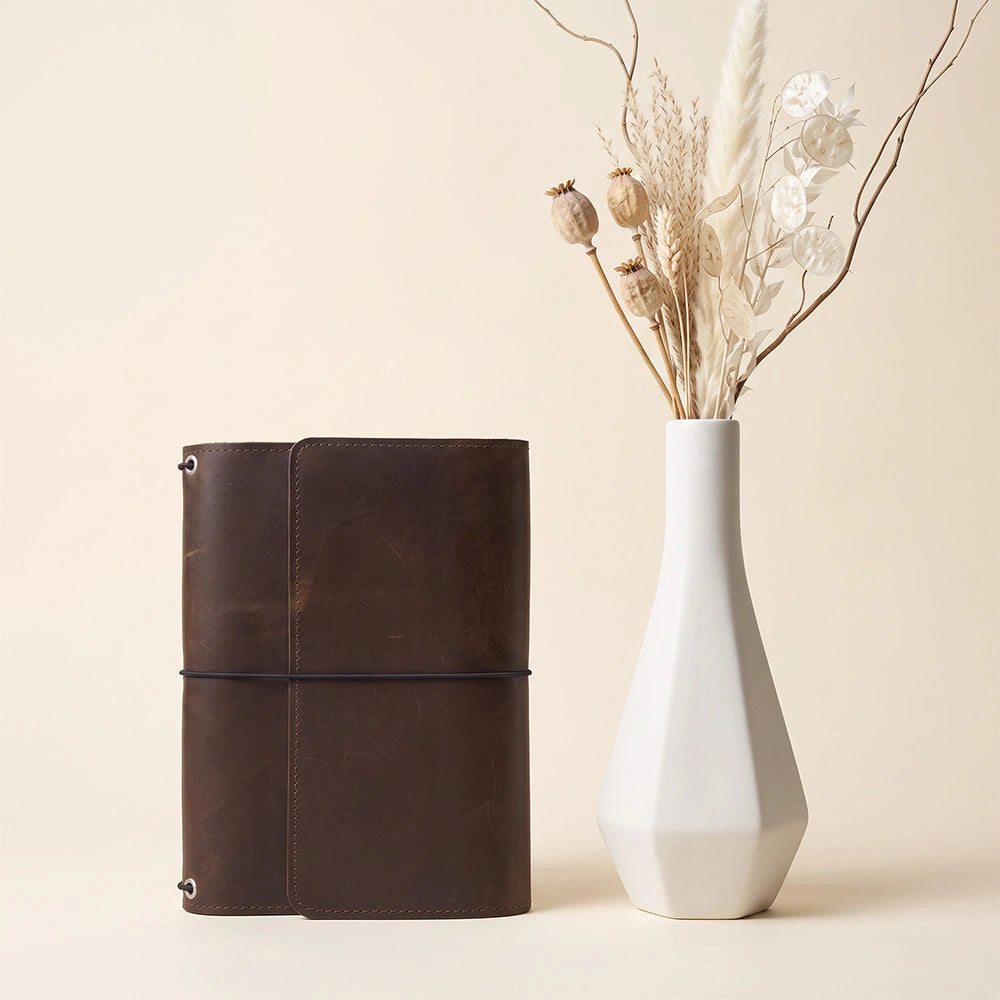 Durable refillable journal cover with interior storage pockets and integrated pen loop feature.