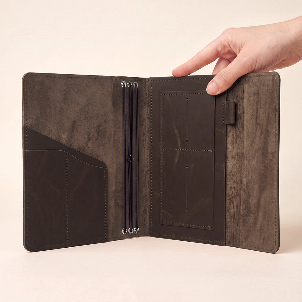 Leather notebook organizer crafted from genuine leather with inner pockets and pen holder.
