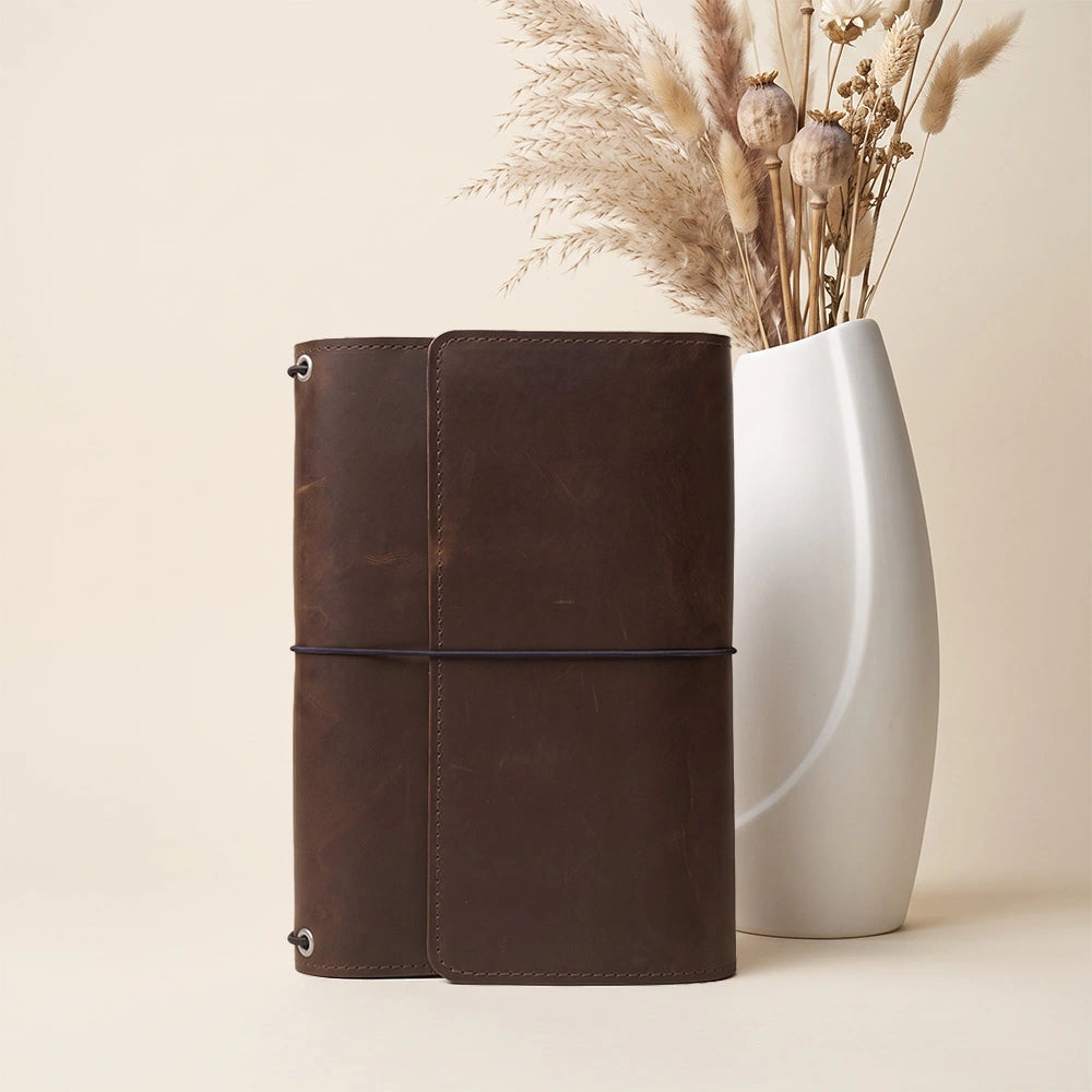 Leather notebook organizer crafted with thoughtful storage layout and integrated writing loop.