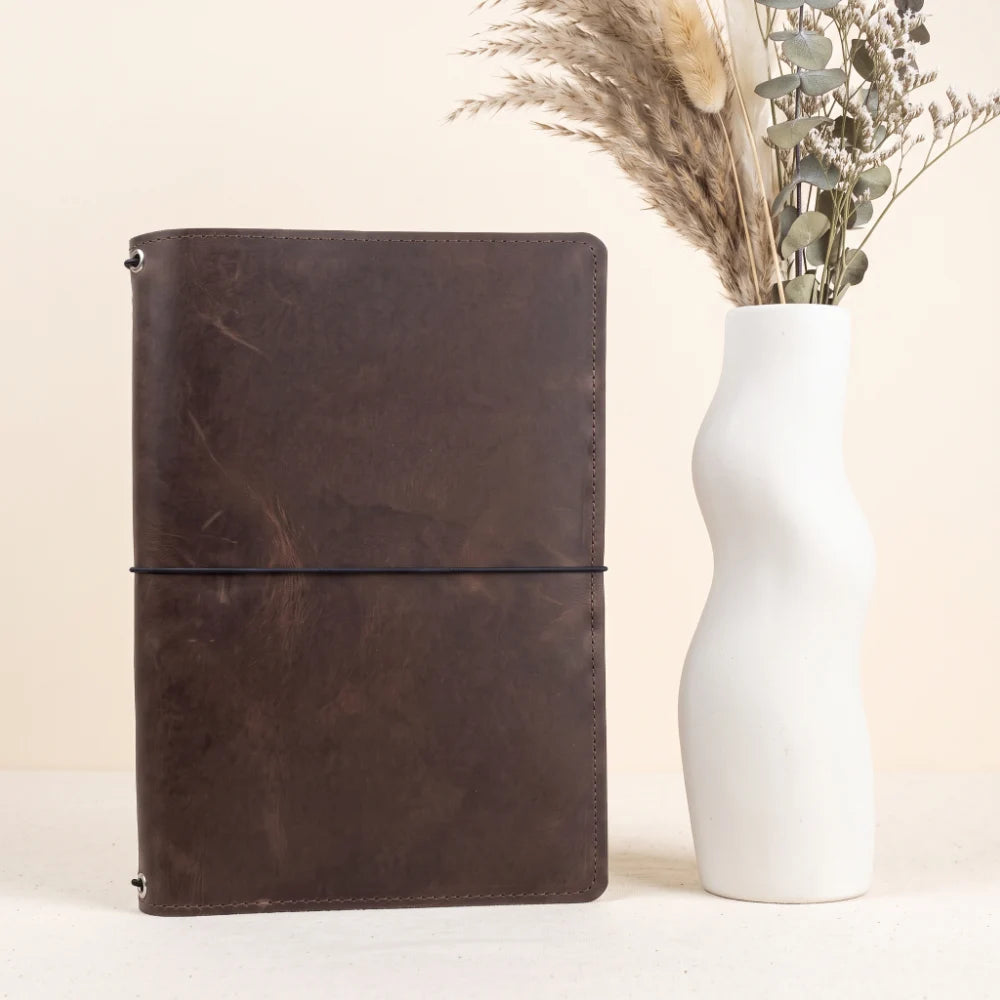 Leather notebook organizer with three interior stretch cords for interchangeable refills.