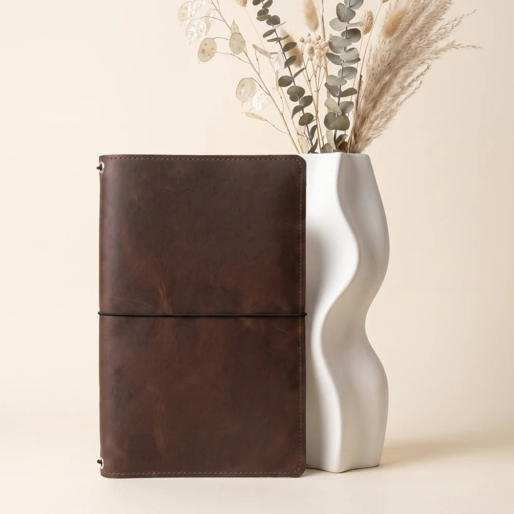 Handmade leather journal wrap with three stretch bands for replaceable notebook refills.