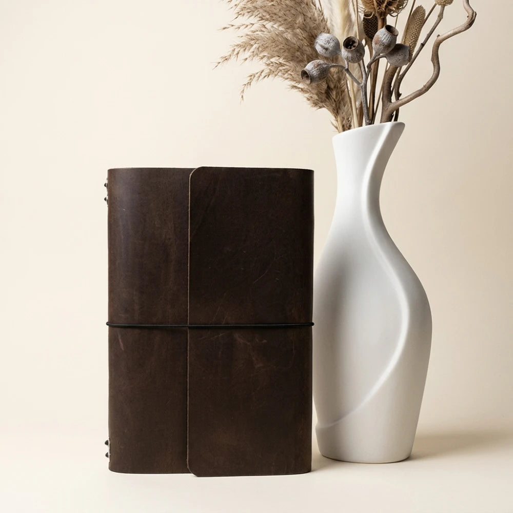 Minimalist refillable notebook case crafted from genuine leather for six inserts.