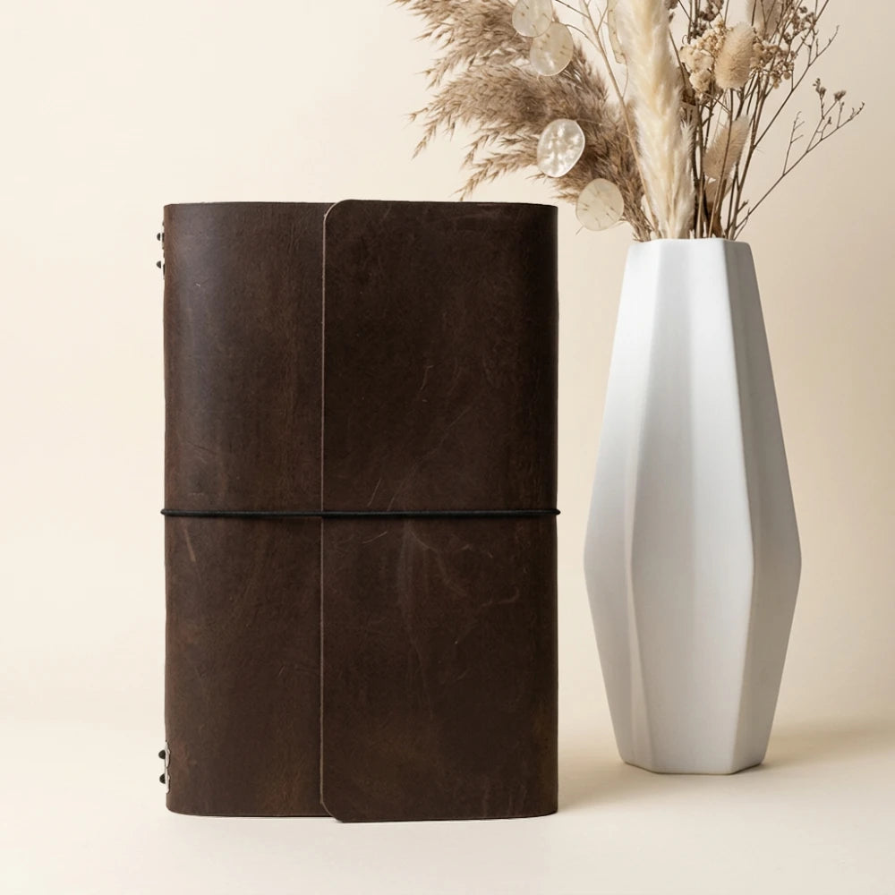Reusable leather journal wrap providing six elastic positions for interchangeable notebook refills.