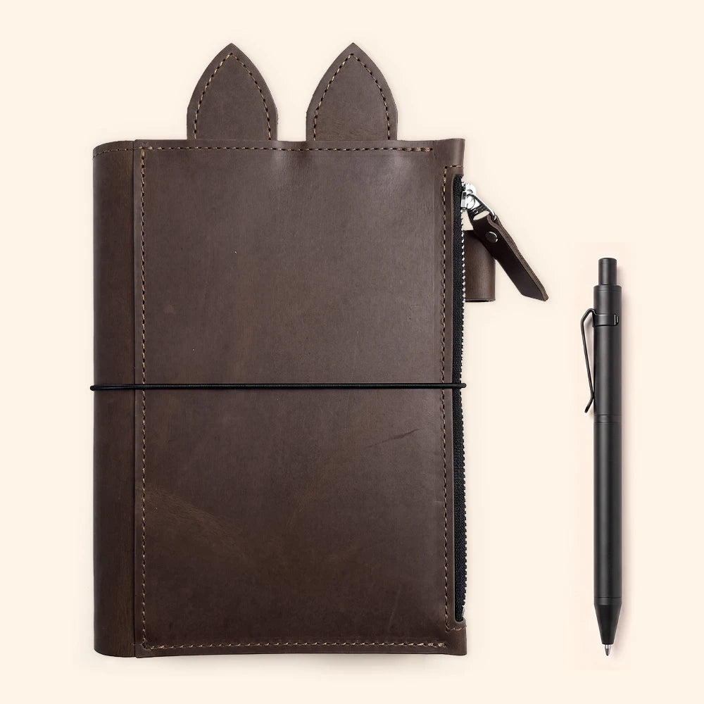 Handcrafted brown planner cover featuring three elastic straps for refillable notebook inserts.
