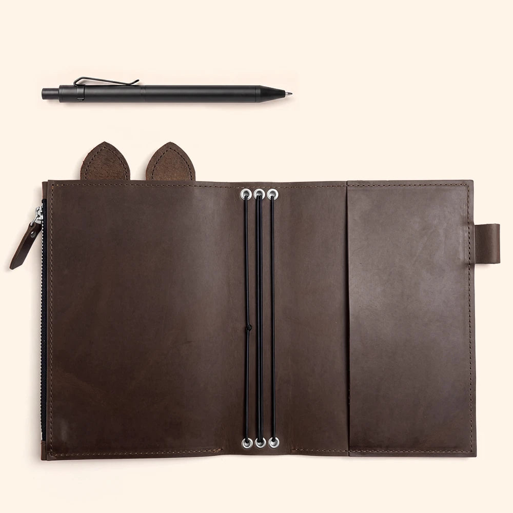 Open brown leather planner featuring three elastic loops running through reinforced eyelets.