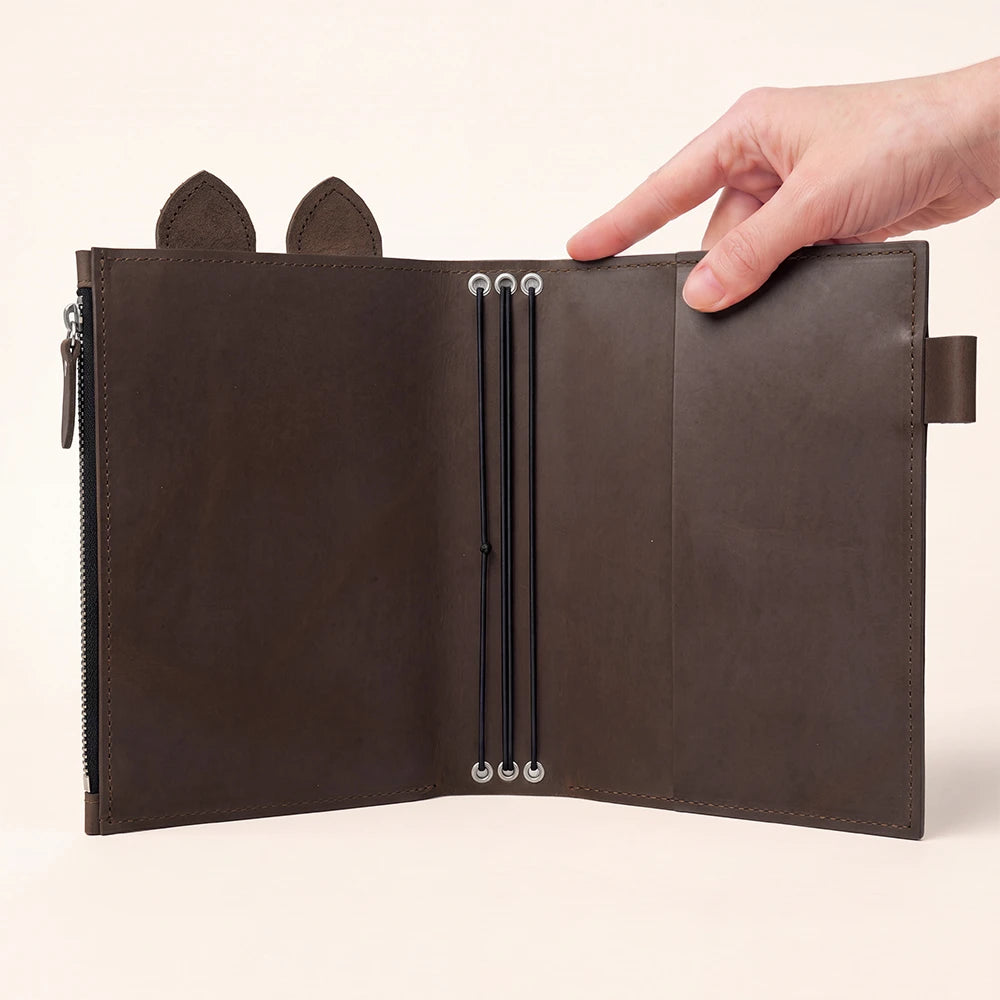 Rustic leather notebook cover featuring roomy zipper compartment, pen loop, decorative ears, and three bands.