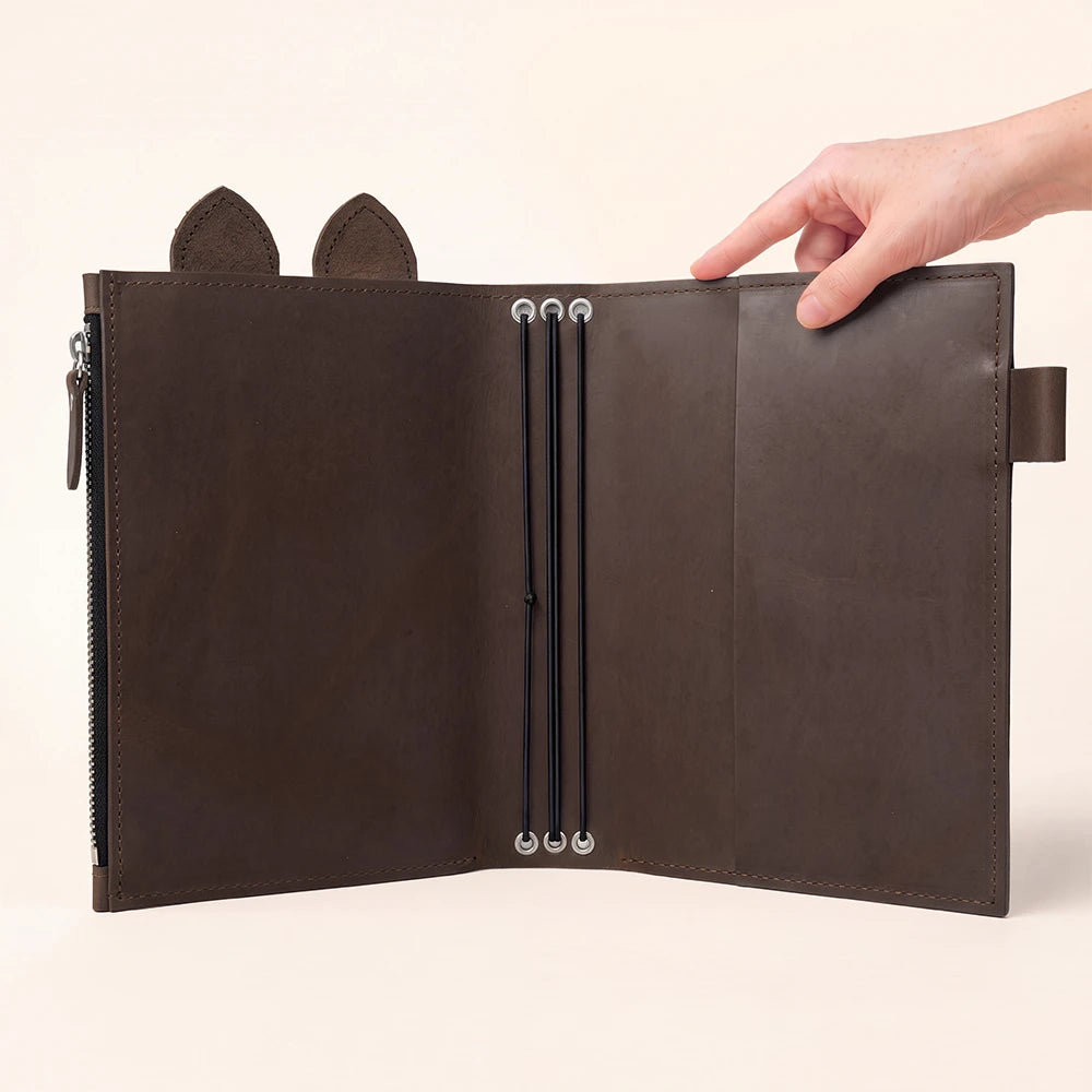 Open leather planner with a spacious pocket secured by a durable zipper.