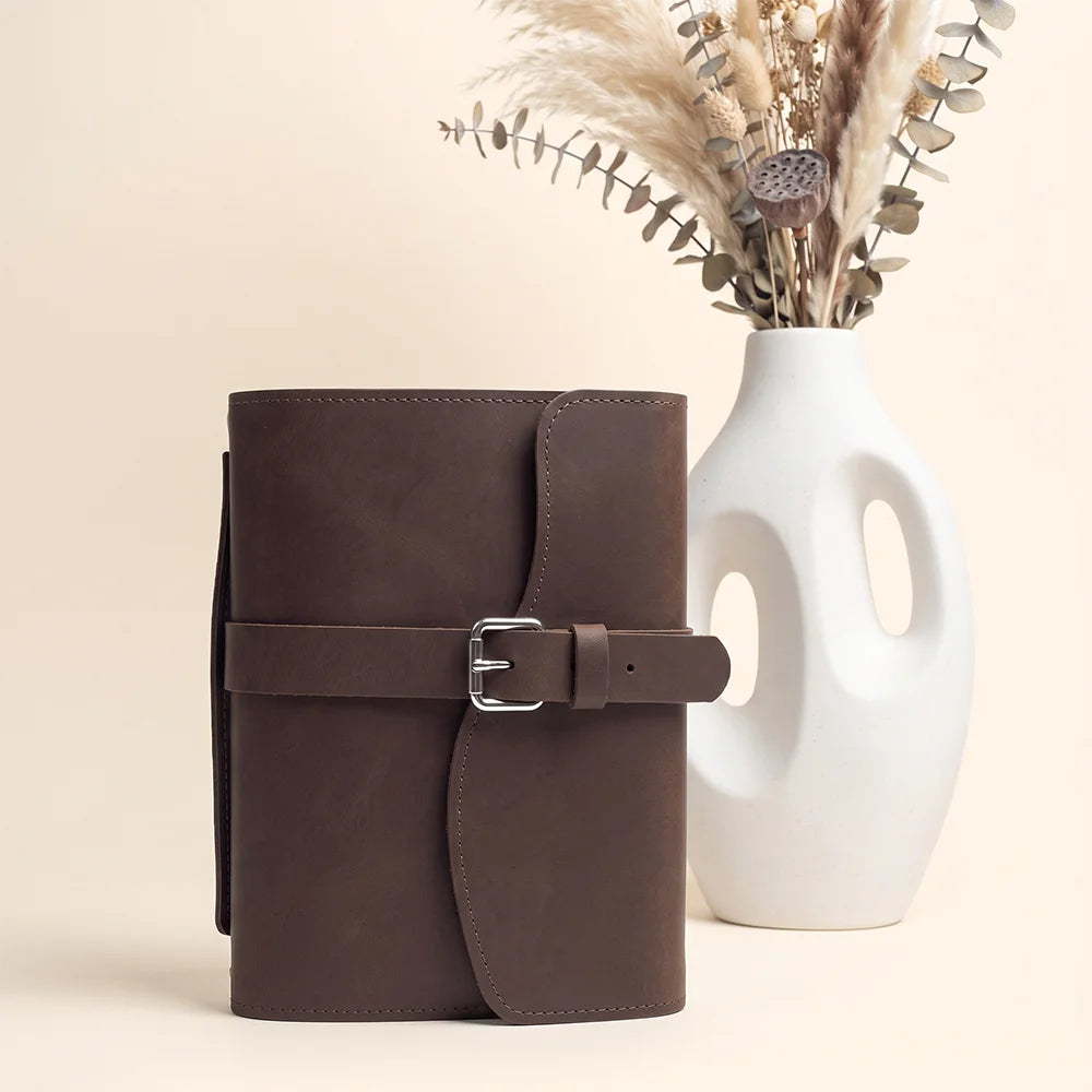 Handmade leather notebook holder with inner pockets, pen loop, bookmark ribbon, and sturdy external grip.