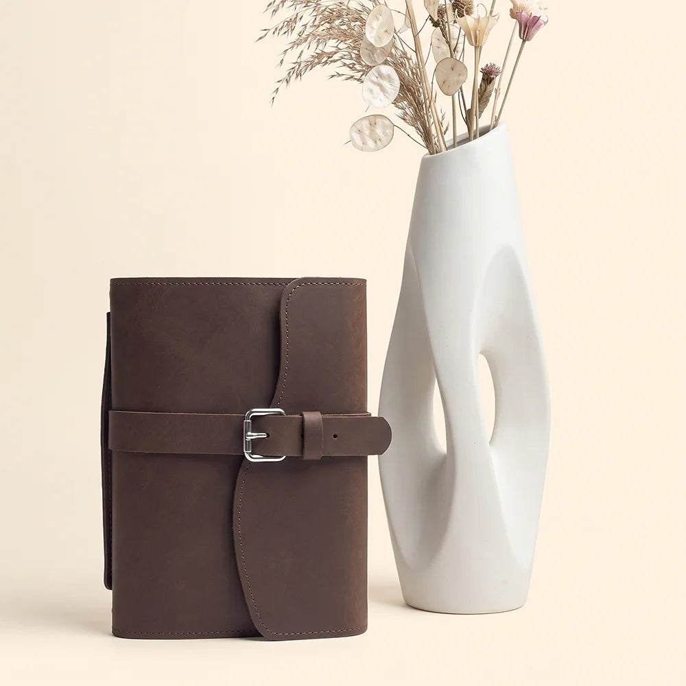 Premium leather notebook organizer featuring interior pockets, pen loop, page marker, and comfortable exterior handle.