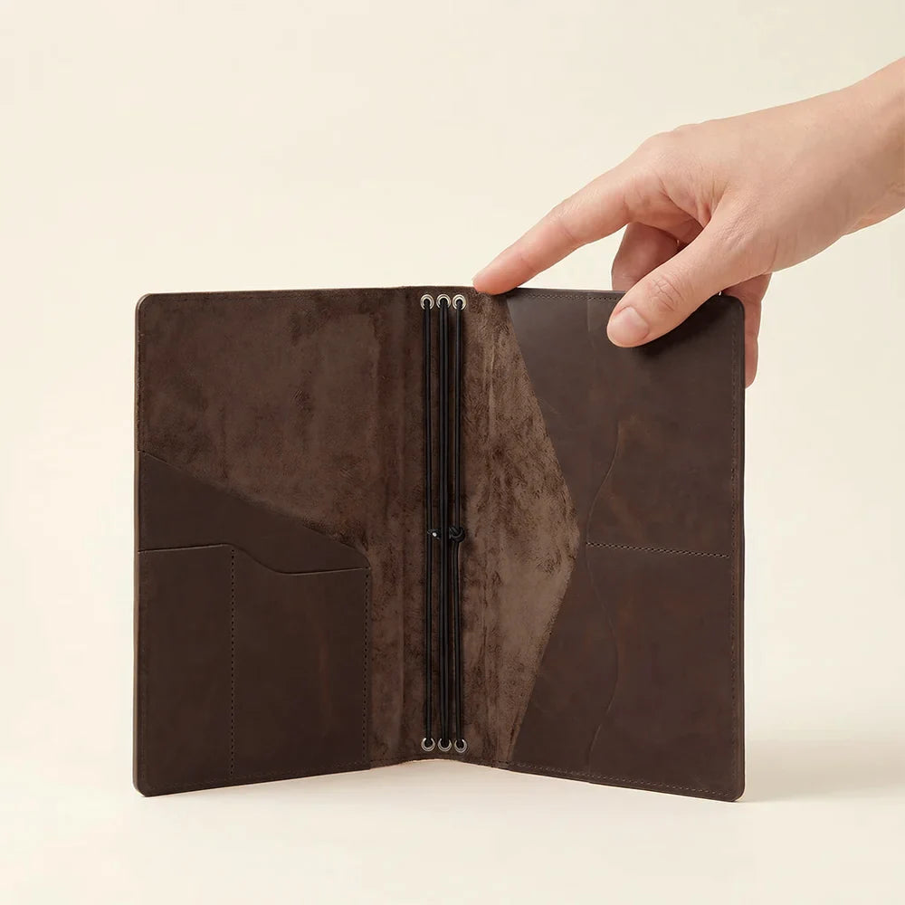 Refillable leather notebook organizer with card pockets and three elastic notebook bands inside.