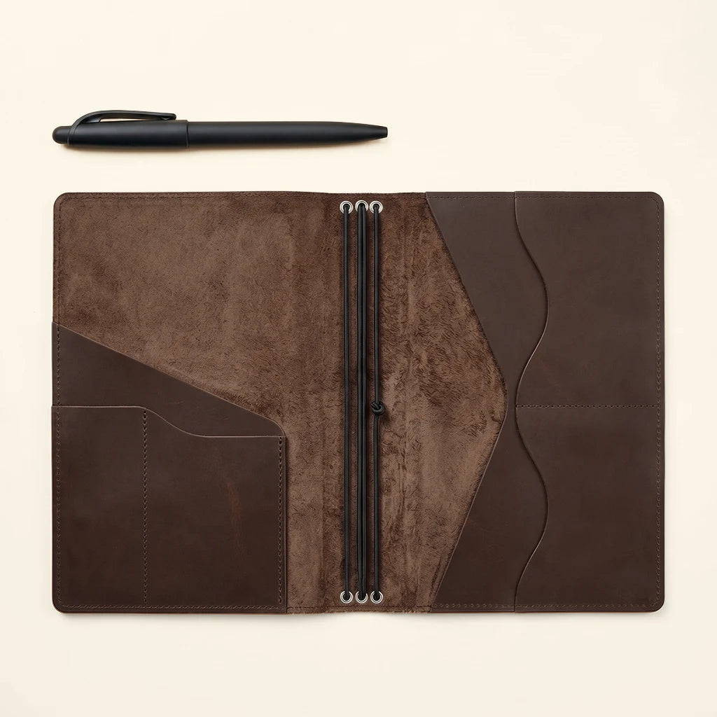 Personalized leather notebook cover with inner compartments and elastics.