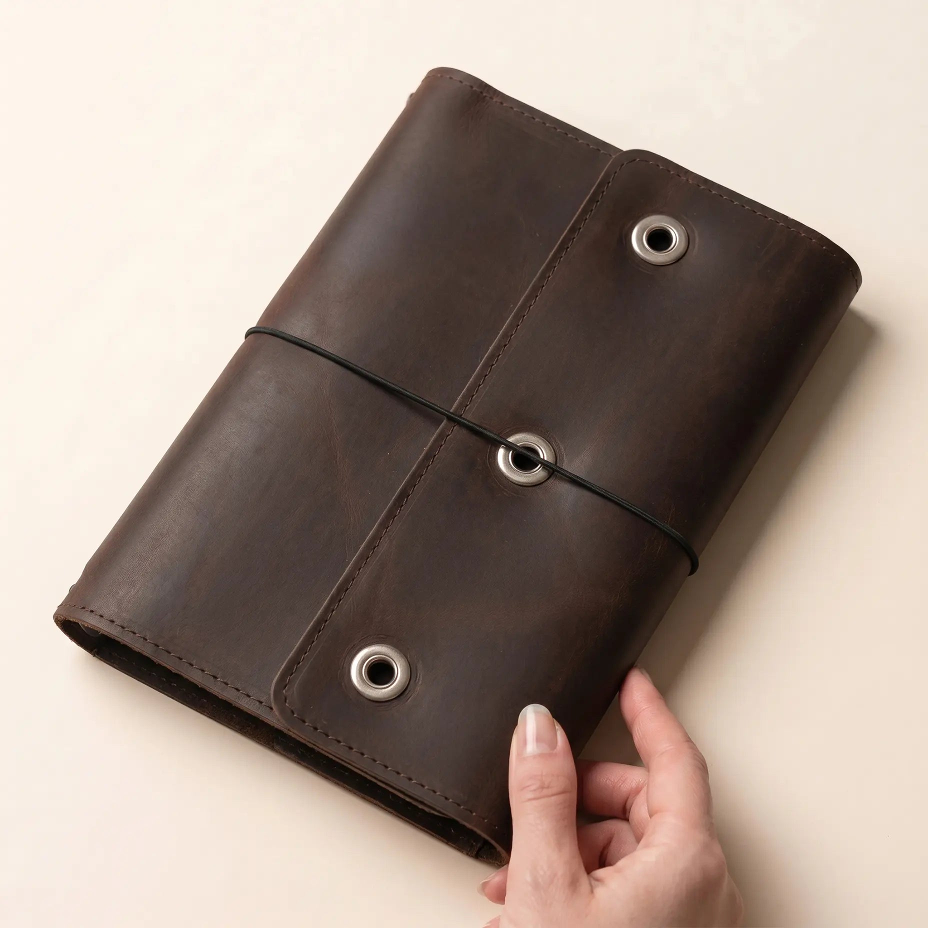 Rustic leather notebook cover with pen holder and card pockets.