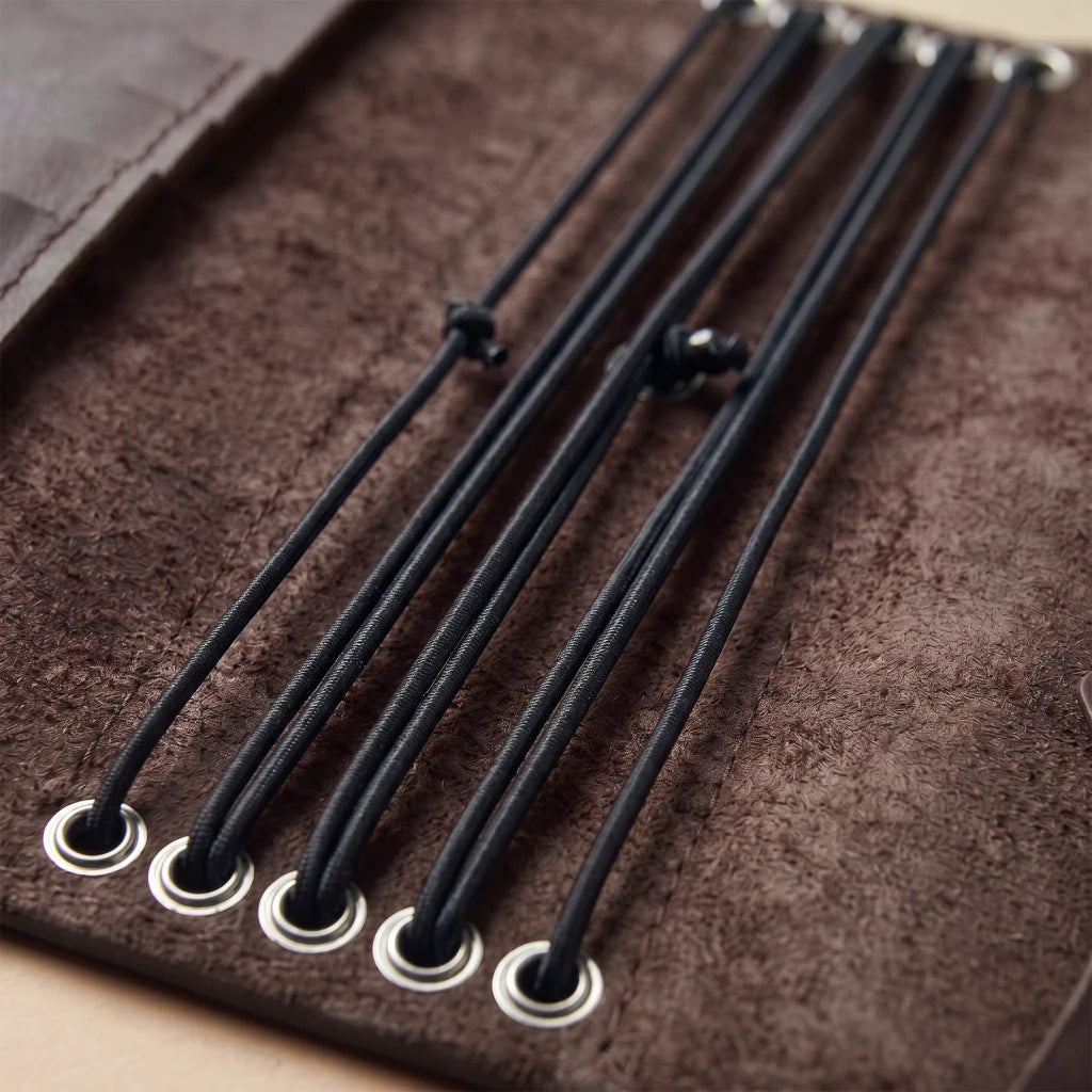 Leather notebook case featuring elastic bindings and interior pockets