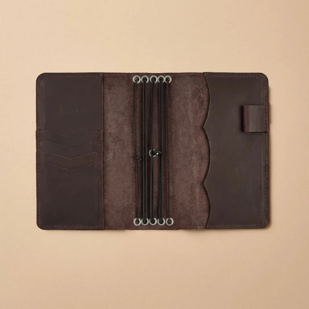 Leather travel journal cover with five elastics and card pockets.