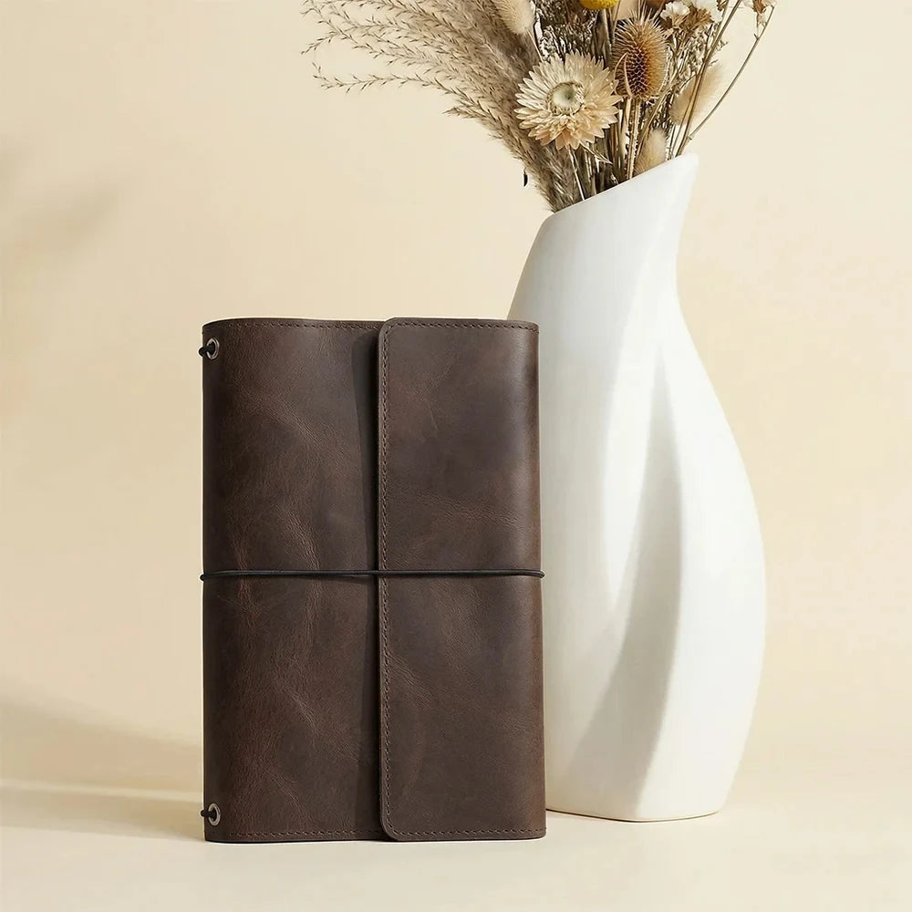 Rustic handmade leather journal cover with three elastics and practical internal storage pockets.