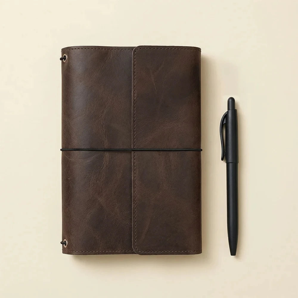 Brown handcrafted leather notebook cover with three elastics and convenient interior organization pockets.