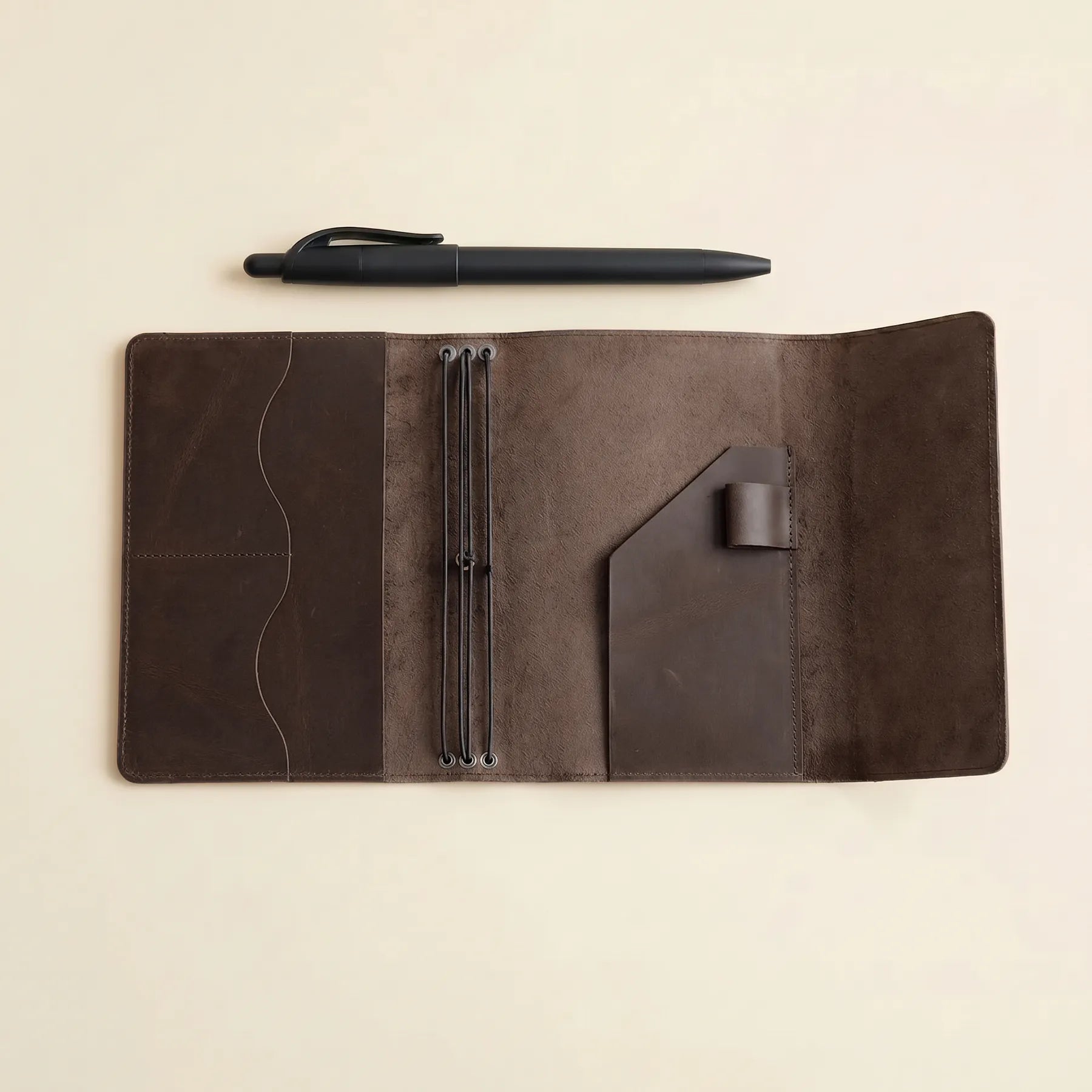 Refillable leather journal cover featuring three elastics and interior card pockets.
