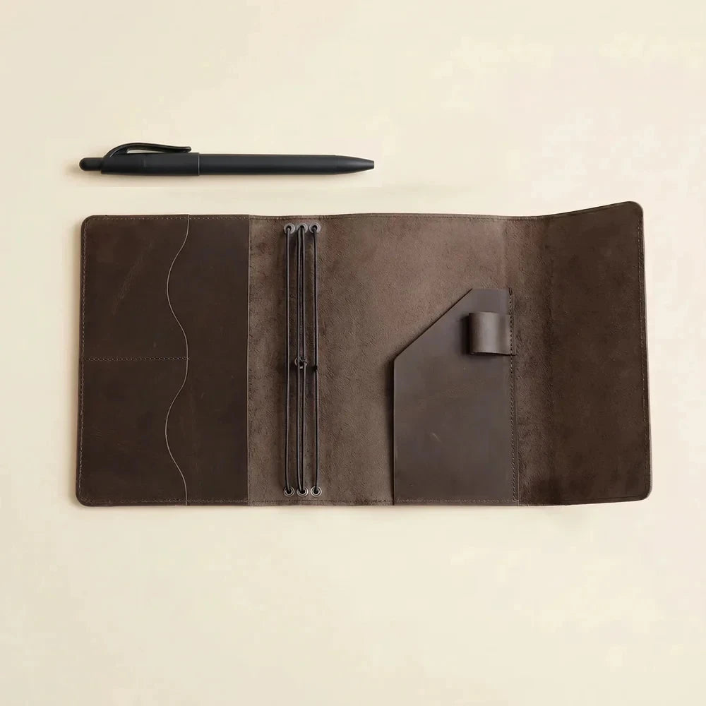 Brown leather notebook cover with three elastic bands and interior storage pockets