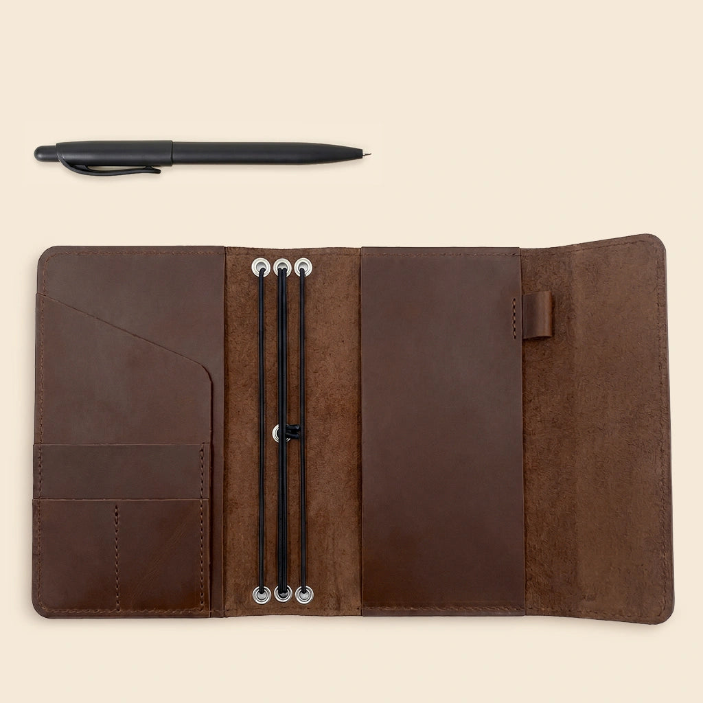 Elegant leather journal case with flexible elastic inserts and interior card storage.