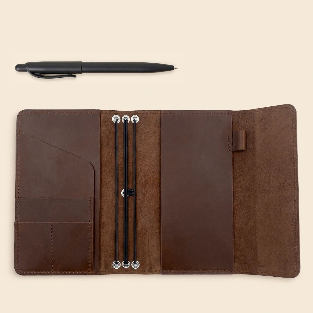 Leather notebook organizer featuring inner pockets, elastic straps, and practical pen holder.