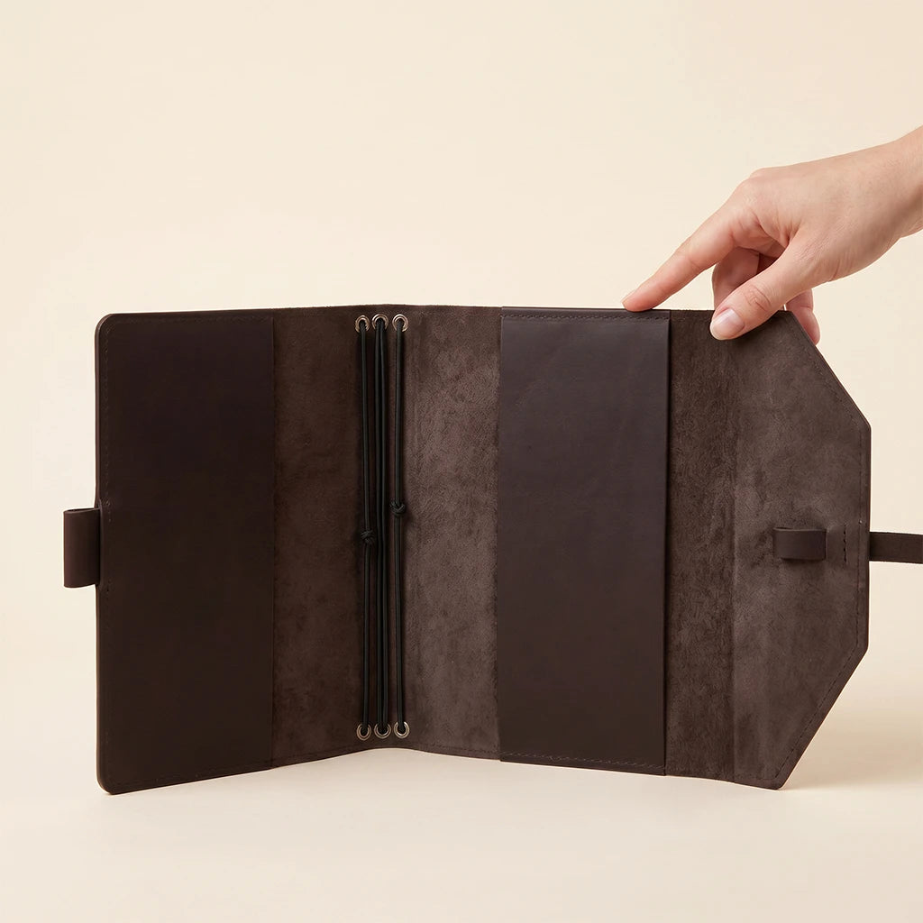 Leather notebook accessory with secure closure bands and dedicated pen holder.