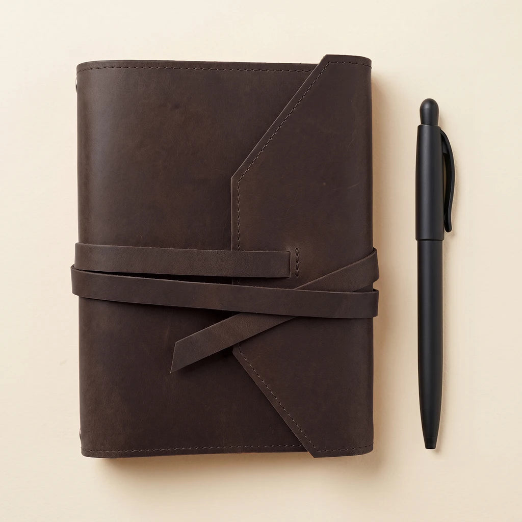 Handmade notebook cover in genuine leather with pen loop and elastic closure.