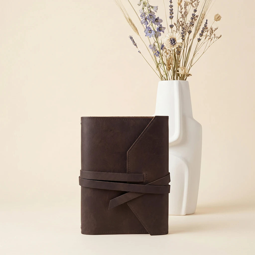 Personalized leather notebook cover with elastic fastening and pen loop feature.