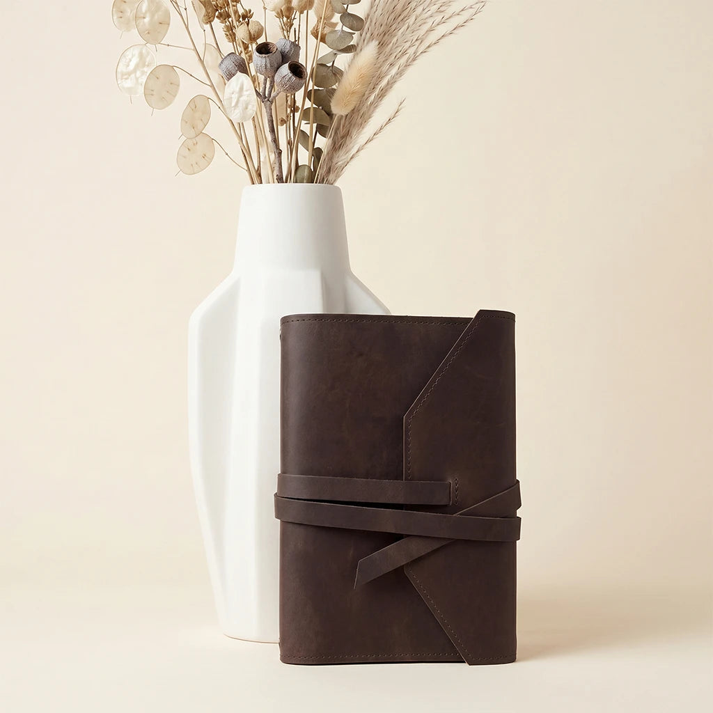 Handmade leather journal organizer featuring elastic fastening and dedicated pen loop.