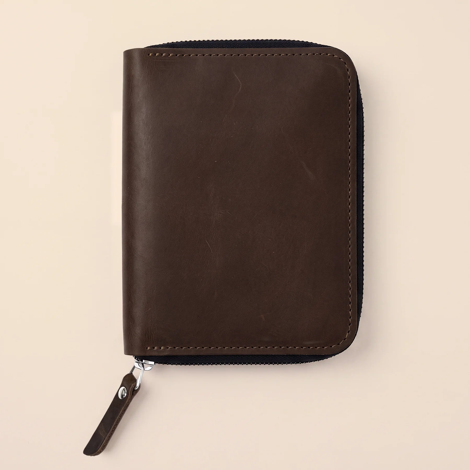 Leather storage sleeve with zipper for protecting pens during work and travel.