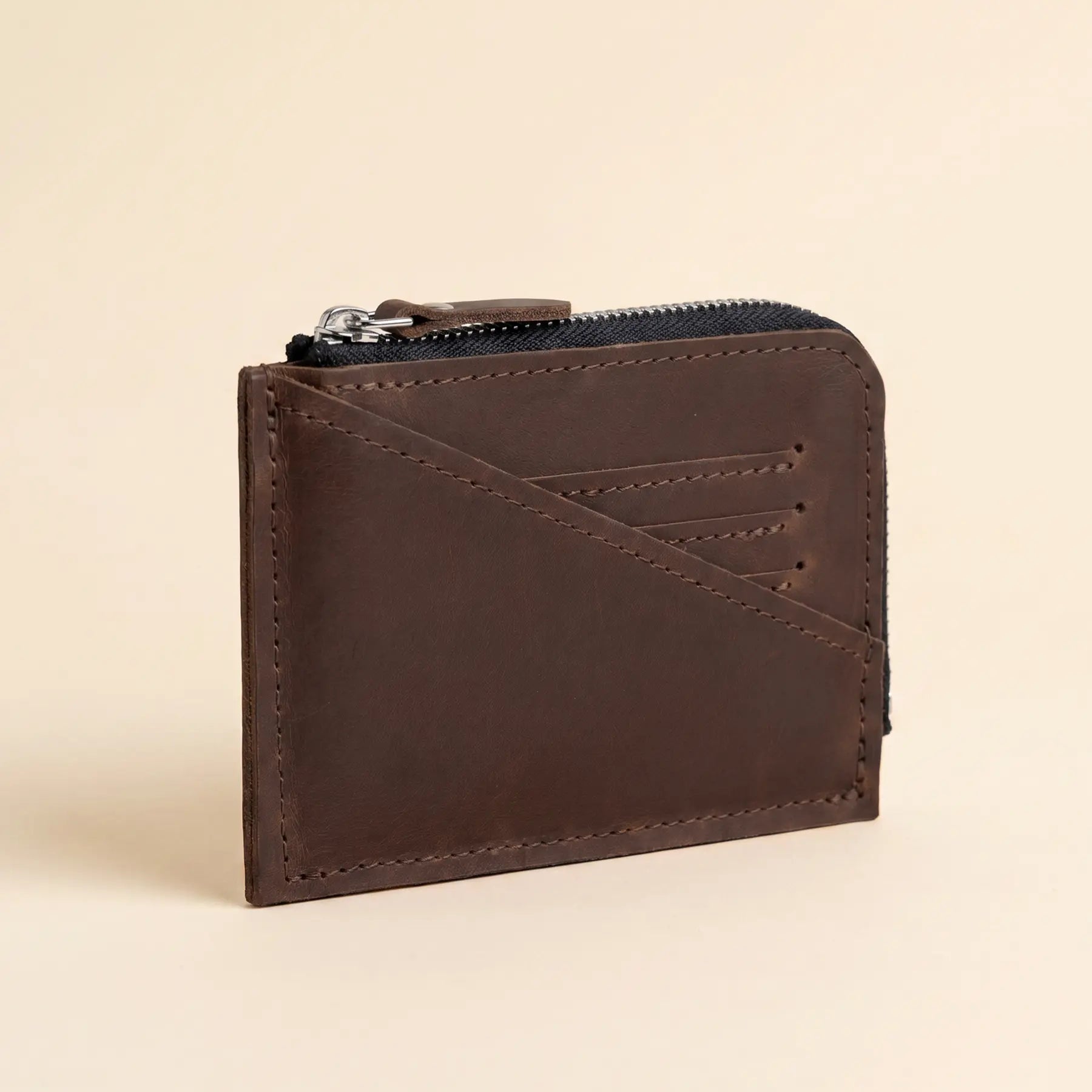 Small leather wallet with zipper closure designed for secure everyday storage of valuables and cards.