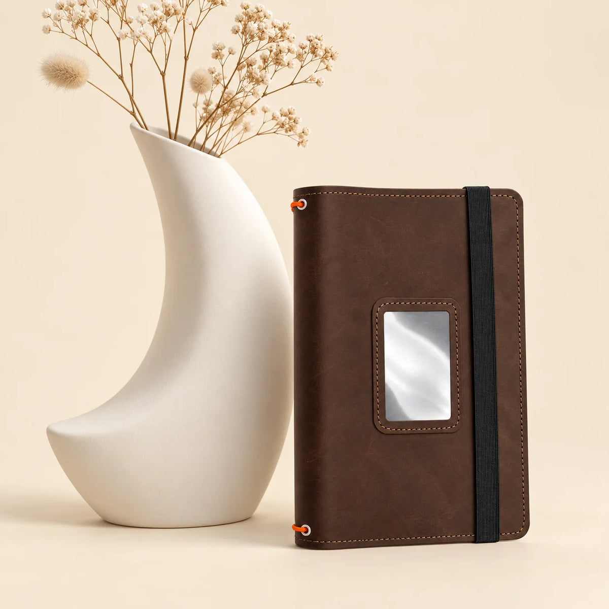 Handmade leather journal cover displaying three secure notebook holders and convenient internal pockets.