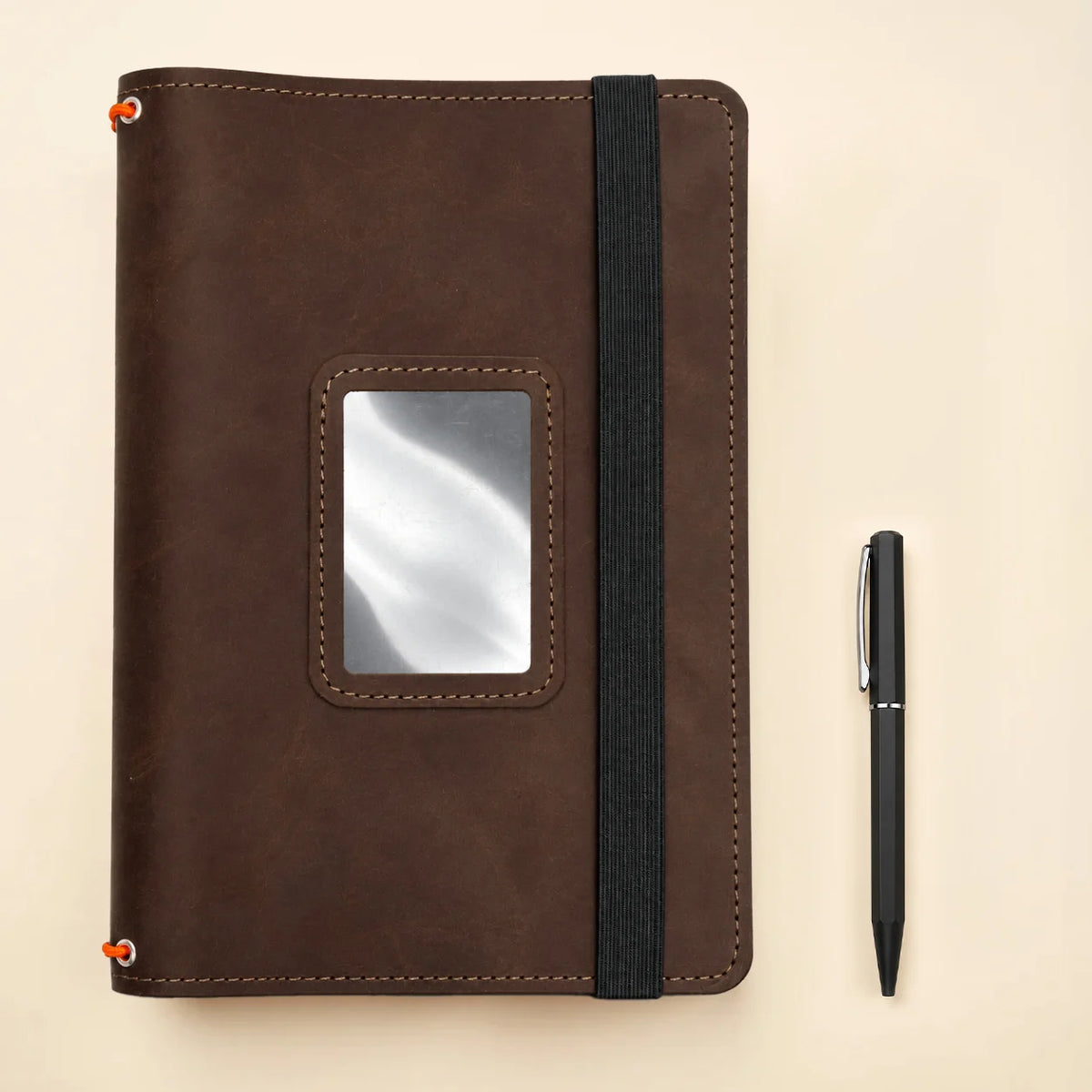Genuine leather notebook case showing three elastic holders and dedicated interior compartments.