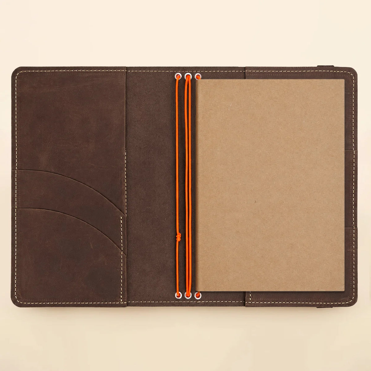 Natural leather notebook cover with three elastic bands and useful compartments for notebooks.