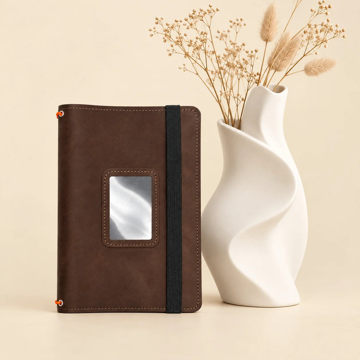 Leather notebook cover with interior storage compartments and three elastic bands for notebooks.