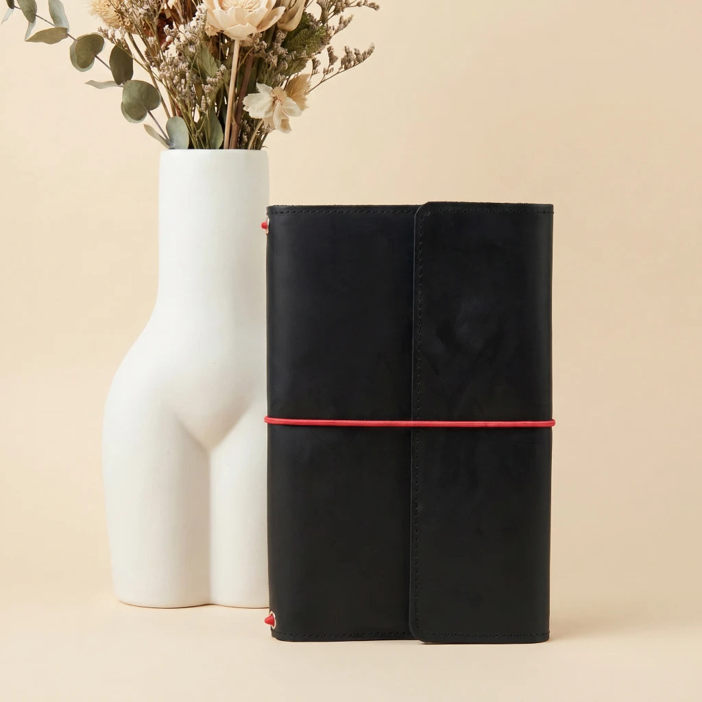 Minimal travel notebook cover in leather with pockets and elastic fastening system