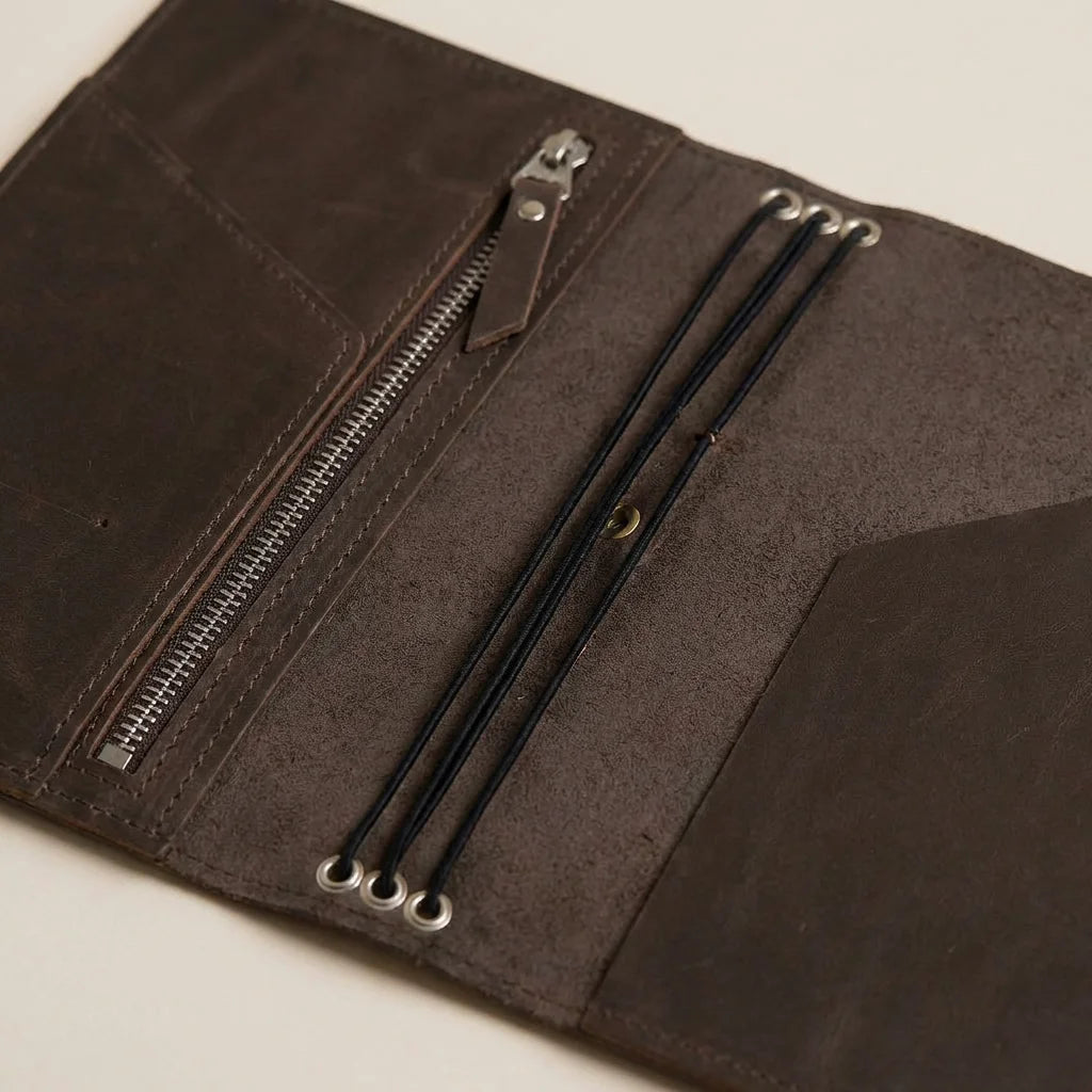 Close-up of a journal leather wallet with zippers on a beige background
