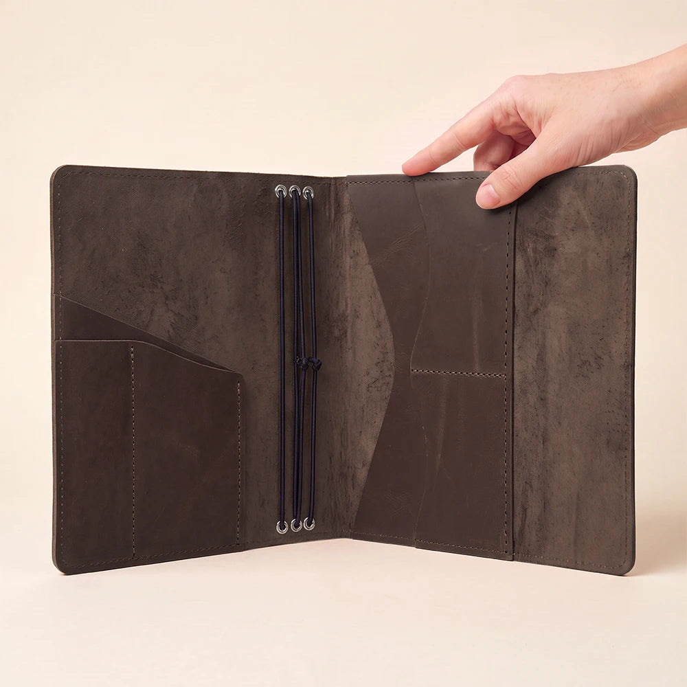 Refillable leather writing journal cover with three elastic cords and organized interior pockets.