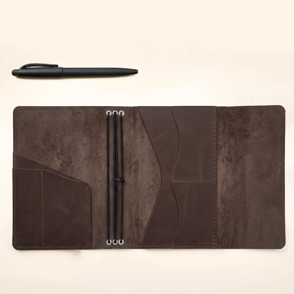 Refillable leather notebook case providing organized storage and secure elastic insert retention.