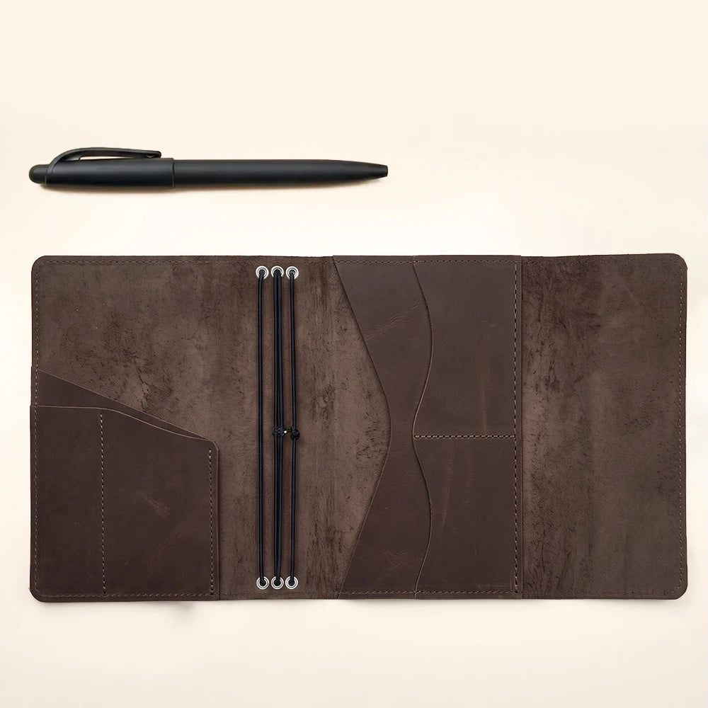 Brown leather notebook cover with interior pockets and secure three elastic band system.