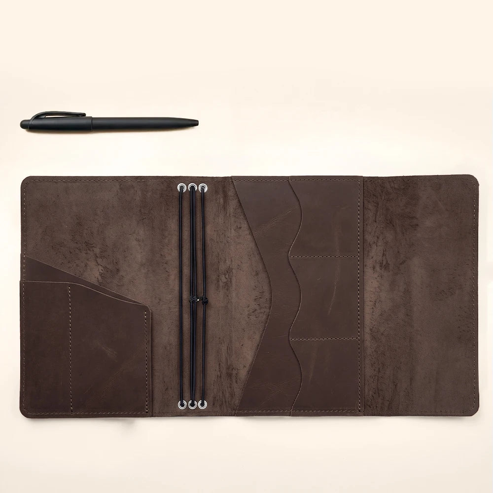 Handcrafted leather notebook wallet with refillable journal design and interior accessory compartments.