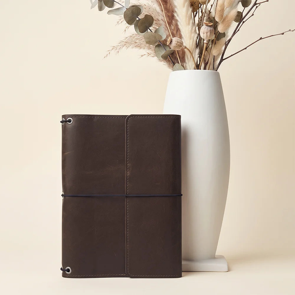 Full grain leather journal cover featuring three elastic bands and organized inner pockets.