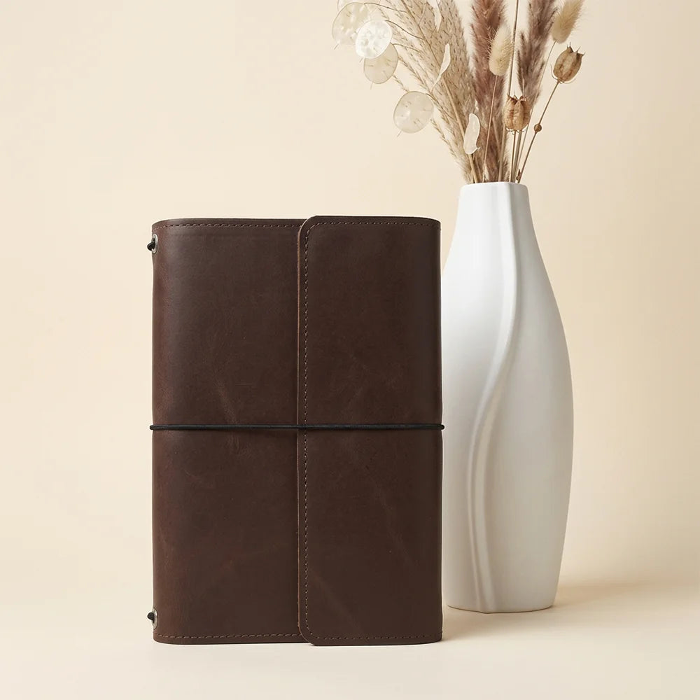 Artisan leather notebook organizer featuring compact storage sections and a practical elastic writing loop.