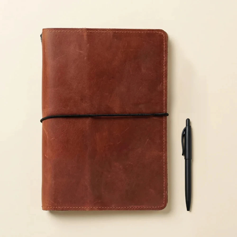 Handmade leather notebook folder with multiple elastic holders and interior utility compartments.