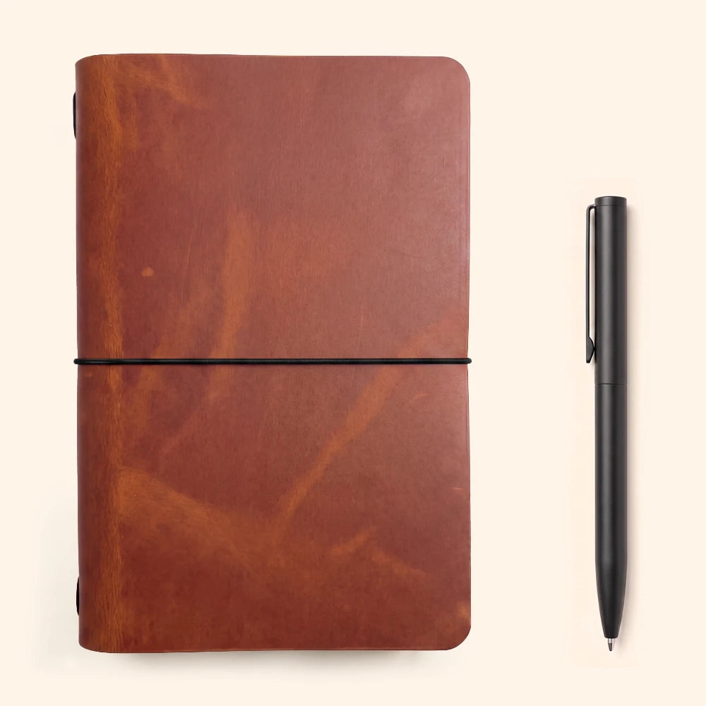 Journal sleeve showing handcrafted leather texture beside plain notebook pages.