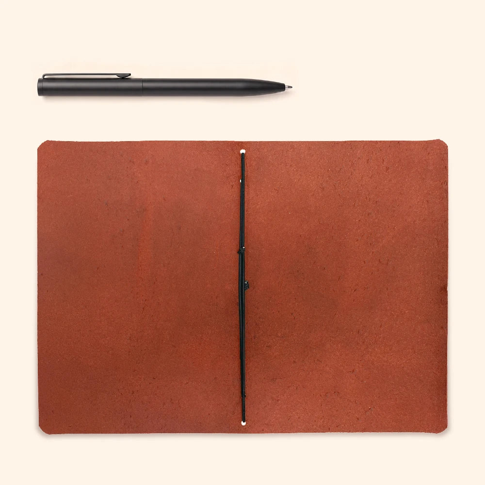Open leather notebook cover displaying a single elastic loop and blank journal insert.